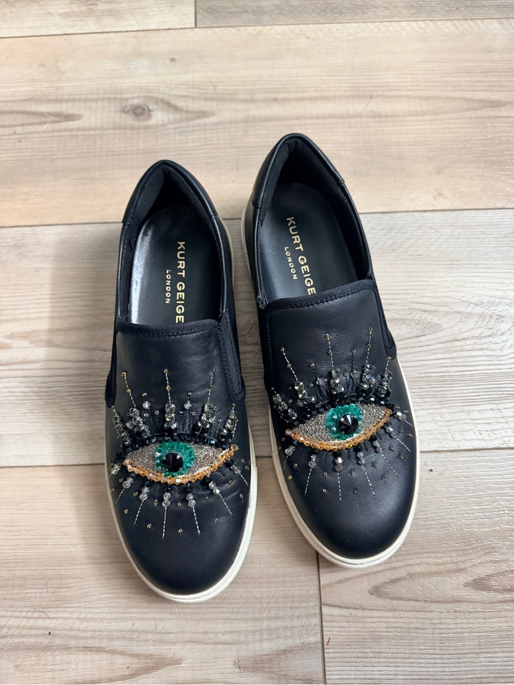 Kurt Geiger Black Slip-On Sneakers with Gold & Green Eye Embellishments